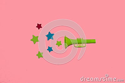 green trumpet from which colorful stars are heard, creative art design on pink background, new information Stock Photo