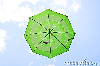 Green umbrella flying on blue sky Stock Photo