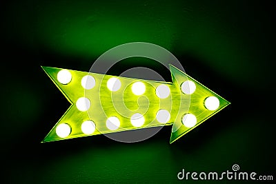 Green vintage bright and colorful illuminated display arrow sign Stock Photo