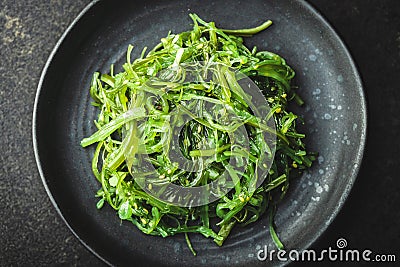 Green wakame. Seaweed salad on black plate Stock Photo
