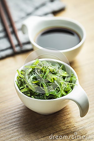 Green wakame. Seaweed salad and soy sauce in bowl Stock Photo