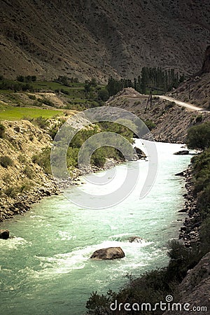 Green water of the mountain river flowing through a valley among Stock Photo
