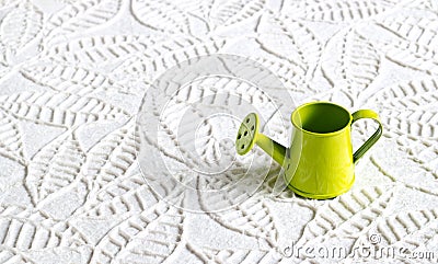 Green watering can on paper texture leaves shape background Stock Photo