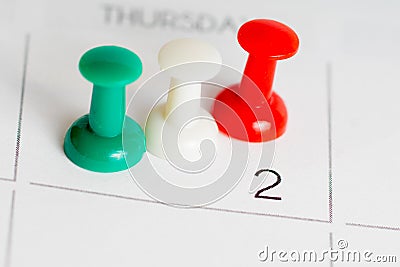 Green white red pins on calendar grid Stock Photo