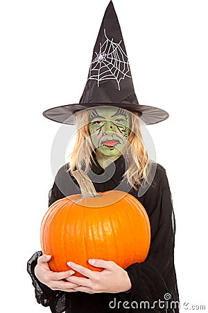 Green witch for halloween holding pumpkin Stock Photo