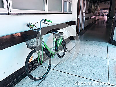 Green woman a bike againtst the white wall Stock Photo