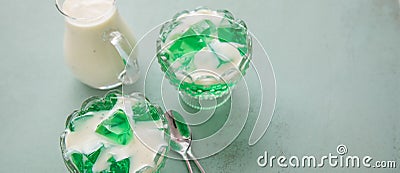 Green woodruff jello with vanilla custard in glass bowls Stock Photo