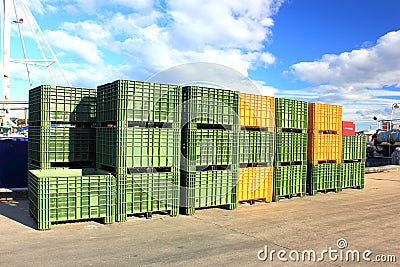 Green and yellow fishing containers on jetty Stock Photo