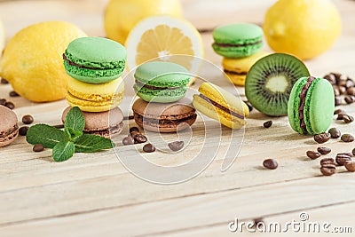 Green and yellow french macarons with kiwi, lemon and mint decorations Stock Photo