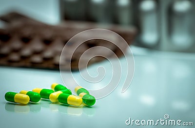 Green, yellow tramadol capsule pills on blurred blister pack background with copy space. Cancer pain management. Opioid analgesic Stock Photo