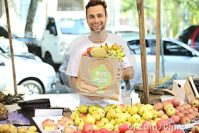 Greengrocer selling organic certified fruits. Stock Photo