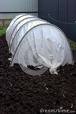 Greenhouse for seedlings on a dug up plot of land Stock Photo