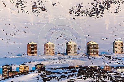 Greenlandic multistorey living buildings with mountains in the b Stock Photo