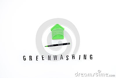 Greenwashing concept with green and black pen and plastic house. Greenwashing marketing ploy products seem more Stock Photo