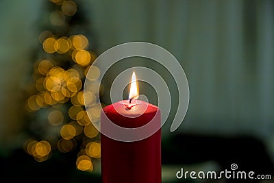Greeting card with copy space.Christmas candles on the background of branches of a Christmas tree and luminous garlands Stock Photo
