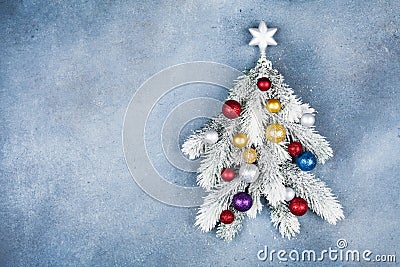 Greeting card with creative Christmas fir tree decorated star and colorful balls on blue background top view. Flat lay. Stock Photo