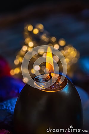 Greeting card Easter burning golden candle. Festive easter concept of candle and yellow eggs on a wooden table. Evening Stock Photo