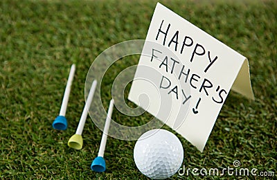 Greeting card with happy fathers day text by golf ball and tees on field Stock Photo