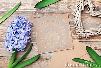 Greeting card on Mothers Day with kraft envelope decorated hyacinth flowers and heart on rustic background. Top view. Stock Photo