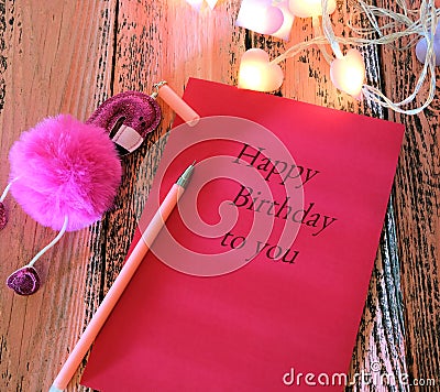 Greeting card with text Happy Birthday to you and Pen with toy pink flamingo . In dark settings. Concept of love and romance Stock Photo