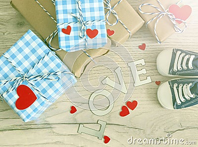 Greeting children card. Blue sneakers and gift boxeswith red heart. Top view Stock Photo