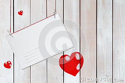 Greeting paper card and three red hearts on wooden white background with copy space Stock Photo