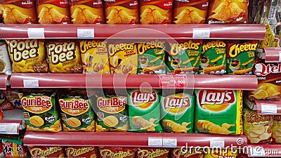 GRESIK, INDONESIA - 13 October 2021: Various snacks and flavored chips on supermarket shelfs. Editorial Stock Photo