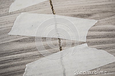 Grey background of broken plywood board with texture sealed with tape Stock Photo