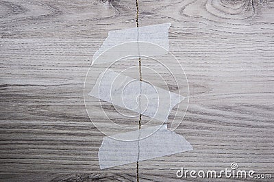 Grey background of broken plywood board with texture sealed with tape Stock Photo