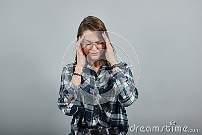 On grey background upset woman tilted her head, has bad mood Stock Photo