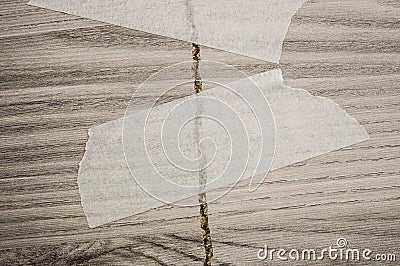 Grey background of broken plywood board with texture sealed with tape Stock Photo