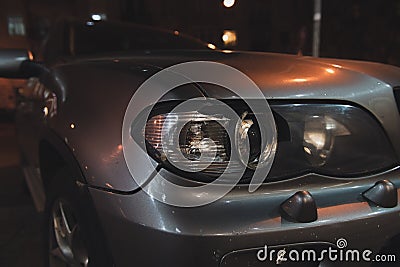 Grey car with broken headlight after a crash accident. Stock Photo