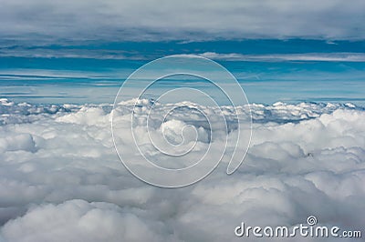 Grey cloud cover seen from above aginst blue sky horizon Stock Photo