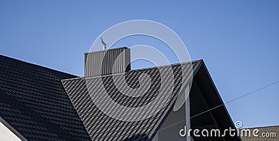 Grey corrugated metal profile roof installed on a modern house. The roof of corrugated sheet. Roofing of metal profile Stock Photo