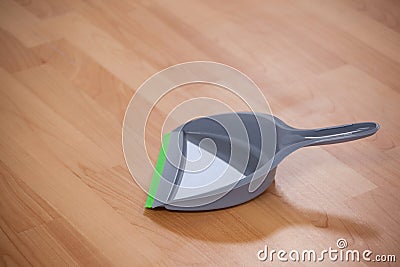 Grey dustpan on wooden floor Stock Photo