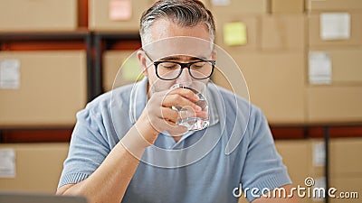 Grey-haired man ecommerce business drinking water at office Stock Photo