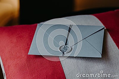 Grey Invitation card for wedding or special occasion on red and white pillow. Wedding decor. Horizontal view. Holiday concept Stock Photo