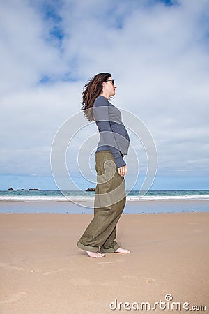 Grey jersey pregnant walking at beach Stock Photo