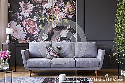 Grey lounge with patterned cushion in real photo of dark living Stock Photo