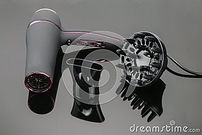 Grey mat hair dryer on the grey mirror background with accessory Stock Photo