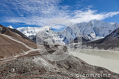 Grey moraine lake and snowy mountain peak in. Stock Photo