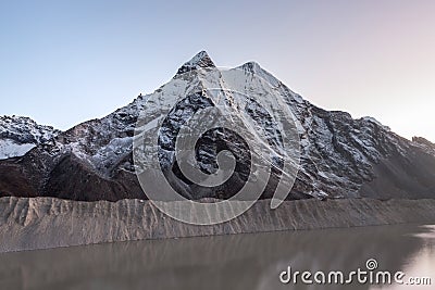 Grey moraine lake and snowy mountain peak in the. Stock Photo