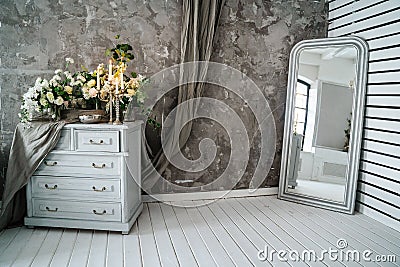 Grey sofa with chest of drawers against a gray wall Stock Photo