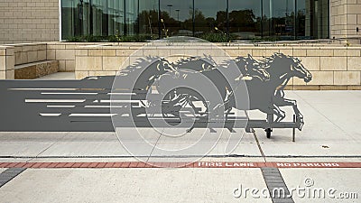 Grey steel cut out of a herd of horses running in front of the Hereford Center at the University of Texas at Arlington. Editorial Stock Photo