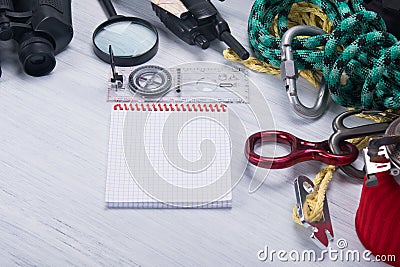 On the grey table, items for extreme sports in the mountains and wildlife, rope, magnifier, compass, binoculars, burner Stock Photo