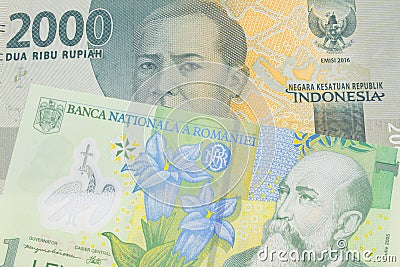 A grey two thousand Indonesian rupiah bank note paired with a green, plastic one leu bank note from Romania. Stock Photo