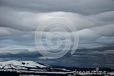 Grey wavy landscape clouds over the winter highlands Stock Photo