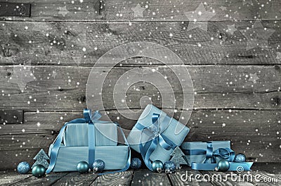 Grey wooden christmas background with a stack of presents in blu Stock Photo