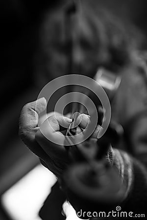 Greyscale image of elderly male musician with dirty nails playing a violin Stock Photo