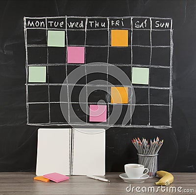 Grid timetable schedule with note paper on black chalkboard back Stock Photo